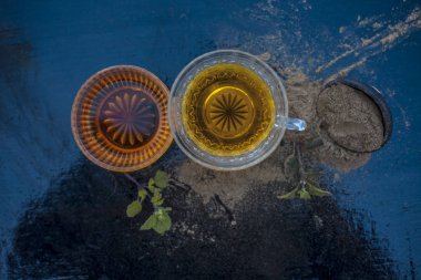 Ayurveda bitki brahmi veya Waterhyssop küçük bir şeffaf cam şişe içinde çay ile birlikte toz ve ahşap yüzeyinde bal bir kase.