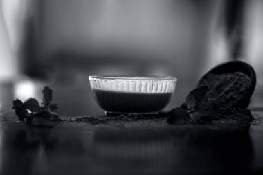 Ayurveda bitki brahmi veya Waterhyssop yararlı hamur ile ahşap yüzeyüzerinde toz ile birlikte bir cam kase.