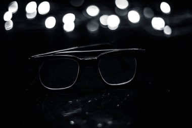 Ahşap yüzeyde siyah renkli veya siyah çerçeveli gözlükler veya okuma gözlükleri.