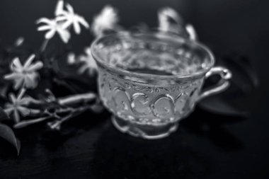 Ham çiçekleri ile cam bir fincan ahşap yüzeyinde Hint yasemin çiçek veya juhi veya Jasminum Auriculatum çay yakın.