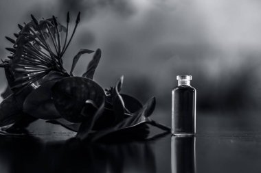 Kırmızı renkli pentas çiçek veya Mısır Star Çiçek veya küçük şeffaf cam şişe onun çıkarılan yararlı çiçek özü veya uçucu yağ ile ahşap yüzeyüzerinde yasemin.