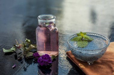 Popüler Hint ve Asya şerbedi yani Gulab ka şerbat veya gül sütü ahşap yüzeyüzerinde hangi batırılmış kefalet tohumları ve gül konsantrasyonu veya özü malzemeler yakın.