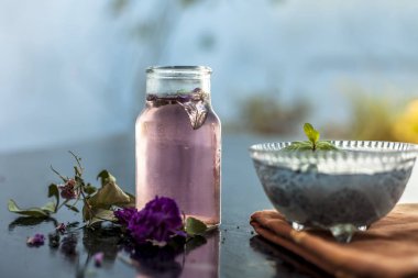 Popüler Hint ve Asya şerbedi yani Gulab ka şerbat veya gül sütü ahşap yüzeyüzerinde hangi batırılmış kefalet tohumları ve gül konsantrasyonu veya özü malzemeler yakın.