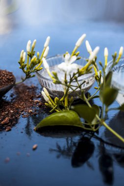 Ahşap yüzey üzerinde bir cam kase hint yasemin Ayurevidik yüz paketi yani yasemin özü iyi sandal ahşap tozu ve su ile karıştırılır. Cilt aydınlatma amacıyla kullanılır.