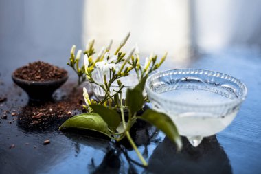 Ahşap yüzey üzerinde bir cam kase hint yasemin Ayurevidik yüz paketi yani yasemin özü iyi sandal ahşap tozu ve su ile karıştırılır. Cilt aydınlatma amacıyla kullanılır.