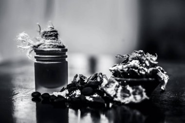 Cam şişede çıkarılan bitkisel ve organik detoksifiye uçucu yağ ile ahşap yüzeyüzerinde bir kil kase içinde Demirhindi veya imli.