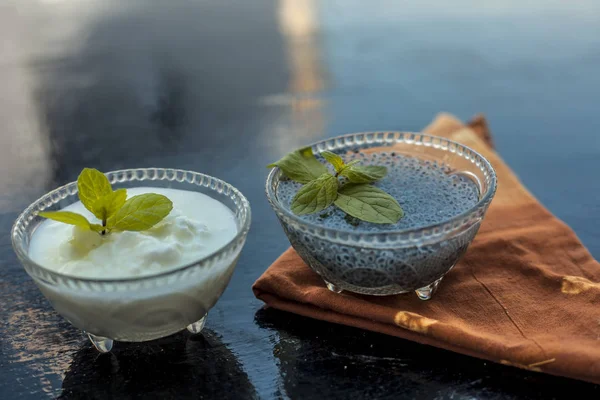 Best and most effective method to reduce weight i.e. Soaked sweet basil seeds well mixed in curd or yogurt.Entire raw ingredients on wooden surface.