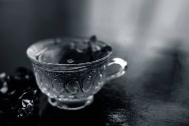 Kavrulmuş tohumları ile birlikte kil bir kapta demirhindi veya imli veya amli ve ahşap yüzey üzerinde nane veya mentha yaprakları ile şeffaf bir cam bardak çay ayıklamak.