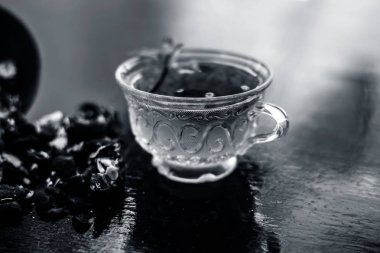 Kavrulmuş tohumları ile birlikte kil bir kapta demirhindi veya imli veya amli ve ahşap yüzey üzerinde nane veya mentha yaprakları ile şeffaf bir cam bardak çay ayıklamak.