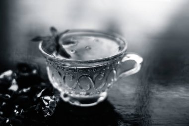 Kavrulmuş tohumları ile birlikte kil bir kapta demirhindi veya imli veya amli ve ahşap yüzey üzerinde nane veya mentha yaprakları ile şeffaf bir cam bardak çay ayıklamak.