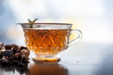 Kavrulmuş tohumları ile birlikte kil bir kapta demirhindi veya imli veya amli ve ahşap yüzey üzerinde nane veya mentha yaprakları ile şeffaf bir cam bardak çay ayıklamak.