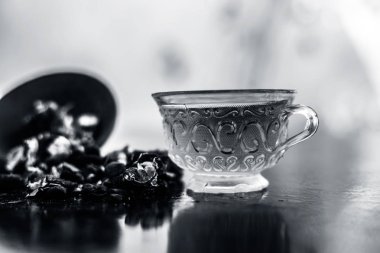 Kavrulmuş tohumları ile birlikte kil bir kapta demirhindi veya imli veya amli ve ahşap yüzey üzerinde nane veya mentha yaprakları ile şeffaf bir cam bardak çay ayıklamak.