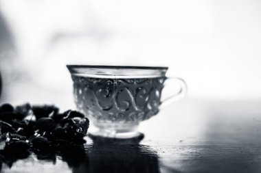 Kavrulmuş tohumları ile birlikte kil bir kapta demirhindi veya imli veya amli ve ahşap yüzey üzerinde nane veya mentha yaprakları ile şeffaf bir cam bardak çay ayıklamak.