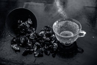 Kavrulmuş tohumları ile birlikte kil bir kapta demirhindi veya imli veya amli ve ahşap yüzey üzerinde nane veya mentha yaprakları ile şeffaf bir cam bardak çay ayıklamak.