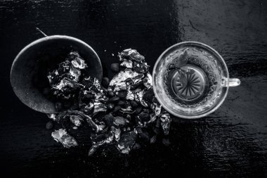 Kavrulmuş tohumları ile birlikte kil bir kapta demirhindi veya imli veya amli ve ahşap yüzey üzerinde nane veya mentha yaprakları ile şeffaf bir cam bardak çay ayıklamak.