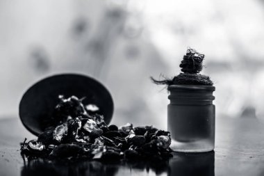 Kavrulmuş tohumları ile birlikte kil bir kapta demirhindi veya imli veya amli ve ahşap yüzeyüzerinde bir cam şişe esansiyel yağ ayıklamak.