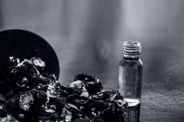 Kavrulmuş tohumları ile birlikte kil bir kapta demirhindi veya imli veya amli ve siyah renkli ahşap yüzey üzerinde bir cam şişe esansiyel yağ veya konsantrasyon veya özü ayıklayın.