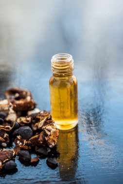 Kavrulmuş tohumları ile birlikte kil bir kapta demirhindi veya imli veya amli ve siyah renkli ahşap yüzey üzerinde bir cam şişe esansiyel yağ veya konsantrasyon veya özü ayıklayın.