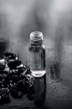 Kavrulmuş tohumları ile birlikte kil bir kapta demirhindi veya imli veya amli ve siyah renkli ahşap yüzey üzerinde bir cam şişe esansiyel yağ veya konsantrasyon veya özü ayıklayın.