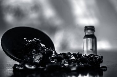 Kavrulmuş tohumları ile birlikte kil bir kapta demirhindi veya imli veya amli ve siyah renkli ahşap yüzey üzerinde bir cam şişe esansiyel yağ veya konsantrasyon veya özü ayıklayın.