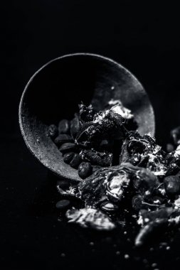 Kavrulmuş tohumları ile birlikte kil bir kapta demirhindi veya imli veya amli ve siyah renkli ahşap yüzey üzerinde bir cam şişe esansiyel yağ veya konsantrasyon veya özü ayıklayın.