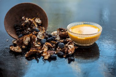 Kavrulmuş tohumları ve çıkarılan macunu veya tentürü ile birlikte kil bir kapta demirhindi veya imli veya amli tahta yüzeyinde kavrulmuş demirhindi tohumu tozu ile birlikte cam bir kapta.