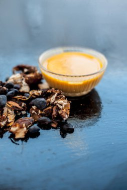 Kavrulmuş tohumları ve çıkarılan macunu veya tentürü ile birlikte kil bir kapta demirhindi veya imli veya amli tahta yüzeyinde kavrulmuş demirhindi tohumu tozu ile birlikte cam bir kapta.