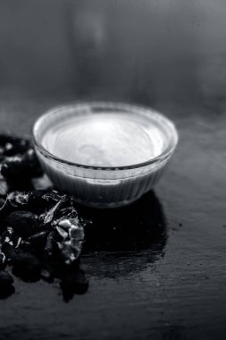 Kavrulmuş tohumları ve çıkarılan macunu veya tentürü ile birlikte kil bir kapta demirhindi veya imli veya amli tahta yüzeyinde kavrulmuş demirhindi tohumu tozu ile birlikte cam bir kapta.