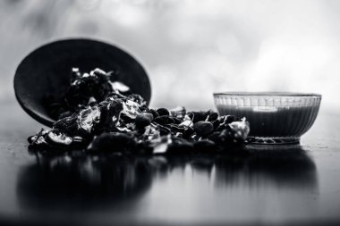 Kavrulmuş tohumları ve çıkarılan macunu veya tentürü ile birlikte kil bir kapta demirhindi veya imli veya amli tahta yüzeyinde kavrulmuş demirhindi tohumu tozu ile birlikte cam bir kapta.