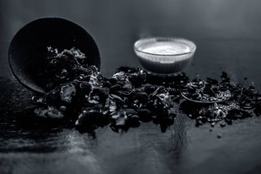 Kavrulmuş tohumları ve çıkarılan macunu veya tentürü ile birlikte kil bir kapta demirhindi veya imli veya amli tahta yüzeyinde kavrulmuş demirhindi tohumu tozu ile birlikte cam bir kapta.