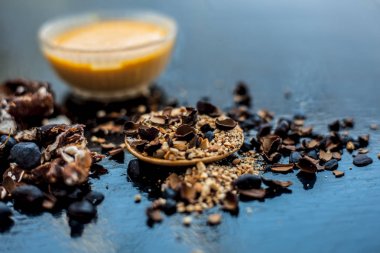 Kavrulmuş tohumları ve çıkarılan macunu veya tentürü ile birlikte kil bir kapta demirhindi veya imli veya amli tahta yüzeyinde kavrulmuş demirhindi tohumu tozu ile birlikte cam bir kapta.