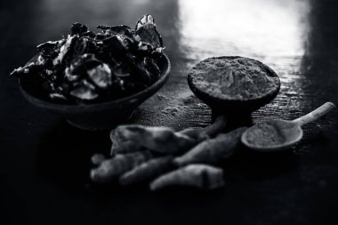 Akne ve sivilce tedavisinde kullanılan kil kase zerdeçal veya haldi ile ahşap yüzeyüzerinde kavrulmuş tohumları ile birlikte bir kil kase içinde demirhindi veya imli veya amli.