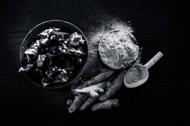 Akne ve sivilce tedavisinde kullanılan kil kase zerdeçal veya haldi ile ahşap yüzeyüzerinde kavrulmuş tohumları ile birlikte bir kil kase içinde demirhindi veya imli veya amli.