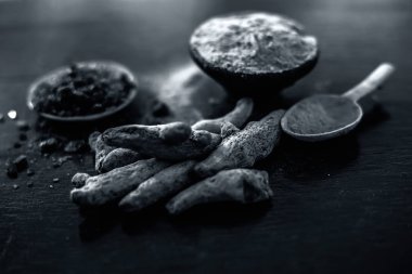 Parlak yüzeyüzerinde başka bir kase bazı ham zerdeçal ve siyah tuz ile birlikte zerdeçal tozu dolu kil kase yakın.