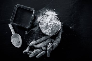 Akne ve sivilce tedavisinde kullanılan kil kase zerdeçal veya haldi ile ahşap yüzeyüzerinde kavrulmuş tohumları ile birlikte bir kil kase içinde demirhindi veya imli veya amli.