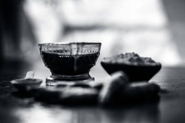 Akne ve sivilce tedavisinde kullanılan kil kase zerdeçal veya haldi ile ahşap yüzeyüzerinde kavrulmuş tohumları ile birlikte bir kil kase içinde demirhindi veya imli veya amli.