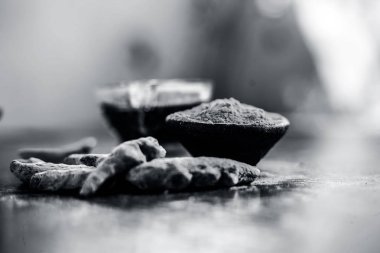 Akne ve sivilce tedavisinde kullanılan kil kase zerdeçal veya haldi ile ahşap yüzeyüzerinde kavrulmuş tohumları ile birlikte bir kil kase içinde demirhindi veya imli veya amli.