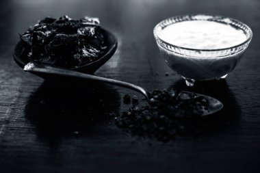 Çeşitli cilt bakım tedavileri için spa kullanılan ahşap yüzeyüzerinde şeffaf cam kase içinde çiğ lor veya yoğurt ile birlikte bir kil kase içinde Demirhindi veya imli veya amli.