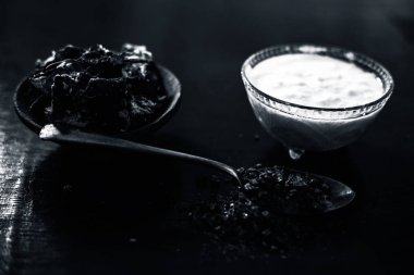 Çeşitli cilt bakım tedavileri için spa kullanılan ahşap yüzeyüzerinde şeffaf cam kase içinde çiğ lor veya yoğurt ile birlikte bir kil kase içinde Demirhindi veya imli veya amli.