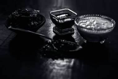 Ham demirhindi, çiğ lor veya yoğurt ve kaya tuzu olan ahşap yüzey üzerinde demirhindi yüz paketi Malzemeler. Mavi renkli cam kase yüz paketi yaptı. Bakterileri deriden temizlemek için kullanılır.