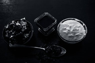 Ham demirhindi, çiğ lor veya yoğurt ve kaya tuzu olan ahşap yüzey üzerinde demirhindi yüz paketi Malzemeler. Mavi renkli cam kase yüz paketi yaptı. Bakterileri deriden temizlemek için kullanılır.