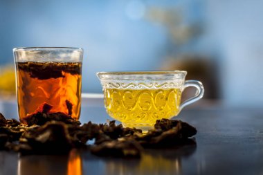 Ham organik amaltas veya altın duş ağacı meyve ahşap yüzeyinde bir bardak su ve yeşil çay ile birlikte bir bardak içinde çıkarılan hamuru ile bir bardak. Bağırsakta solucanların tedavisinde kullanılır.