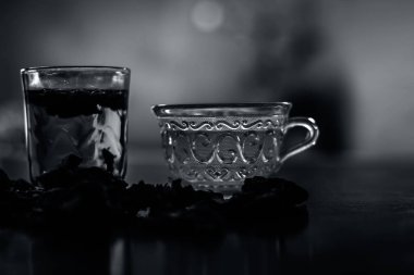 Ham organik amaltas veya altın duş ağacı meyve ahşap yüzeyinde bir bardak su ve yeşil çay ile birlikte bir bardak içinde çıkarılan hamuru ile bir bardak. Bağırsakta solucanların tedavisinde kullanılır.