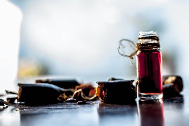 Altın duş ağacı veya garmalo veya Amaltas veya Cassia fistül yağı şeffaf bir cam şişe de meyve ve ahşap yüzeyüzerinde kesilmiş hamuru ile birlikte.