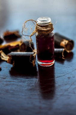 Altın duş ağacı veya garmalo veya Amaltas veya Cassia fistül yağı şeffaf bir cam şişe de meyve ve ahşap yüzeyüzerinde kesilmiş hamuru ile birlikte.