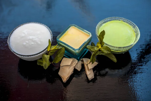 Face pack of fuller\'s earth or mud of multan or bleaching clay on wooden surface along with curd and mint leaves. This face pack is used to nourish,hydrates cleans skin.