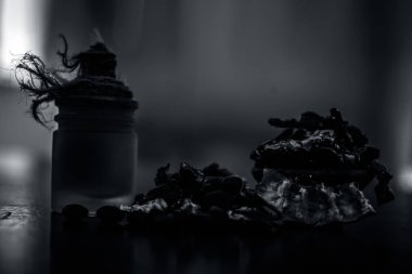 Ham organik amli veya demirhindi veya imli şeffaf bir cam şişe onun çıkarılan bitkisel uçucu yağ ile ahşap yüzeyüzerinde bir kil kase içinde.