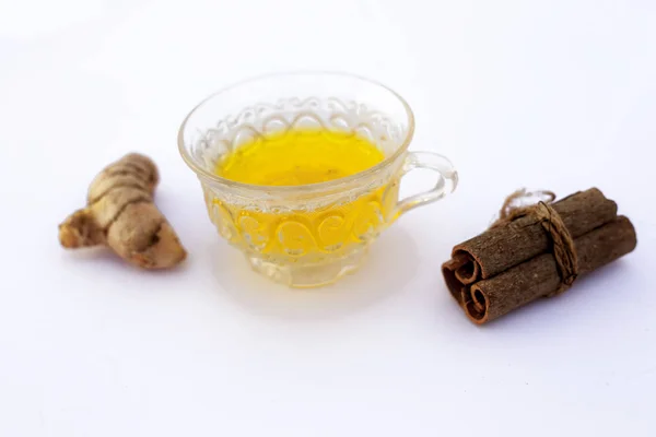 Popular turmeric tea isolated on white with its entire ingredients which are turmeric powder and raw, honey and cinnamon sticks.Used for detoxifying body.Isolated on white.