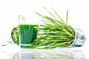 Beyaz camda taze buğday ve buğday çimi suyu izole edilmiş.