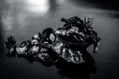 Ahşap yüzeyüzerinde kil bir kapta ham soyulmuş demirhindi veya imli.